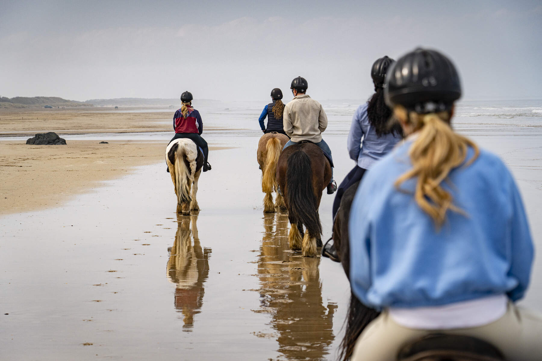 Horse riders on a walk along Downhill Beach