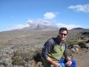 Graham Little poses beside Mount Kilimanjaro